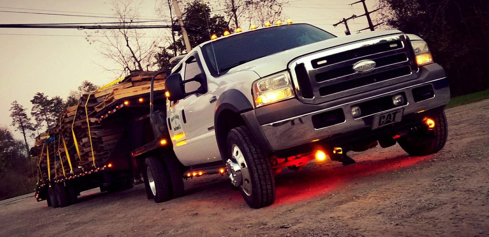 Moore's Hauling truck towing a loaded trailer at dusk